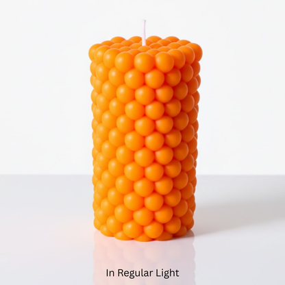 Orange bubble-textured pillar candle on a white background Sensations Unleashed BDSM UV Wax Play Pillar Candle In India In Regular Light.